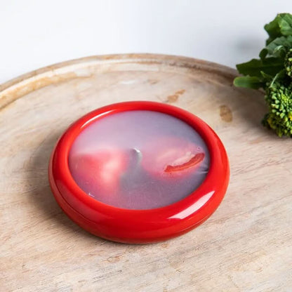 Couvercle rouge sur une moitié de tomate
