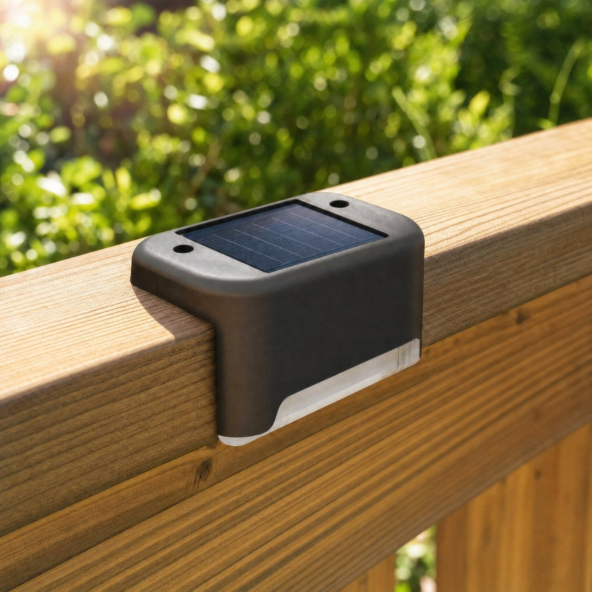 Lampe solaire noire posée sur une rambarde en bois, en plein jour