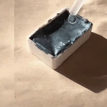 Quelques gouttes d'eau déposées sur un godet d'aquarelle nacrée