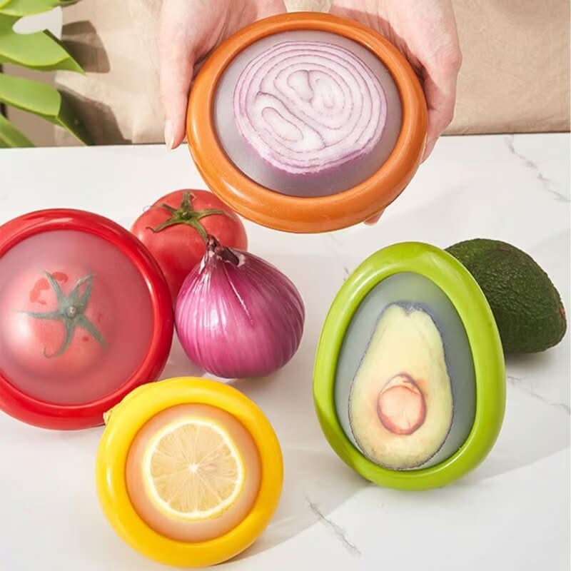 Quatre couvercles extensibles sur une tomate, un citron, un avocat et un oignon coupés