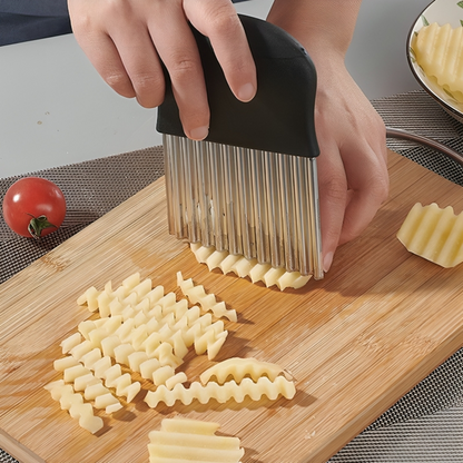 Couteau ondulé Ondulo découpant une pomme de terre en frites ondulées sur une planche