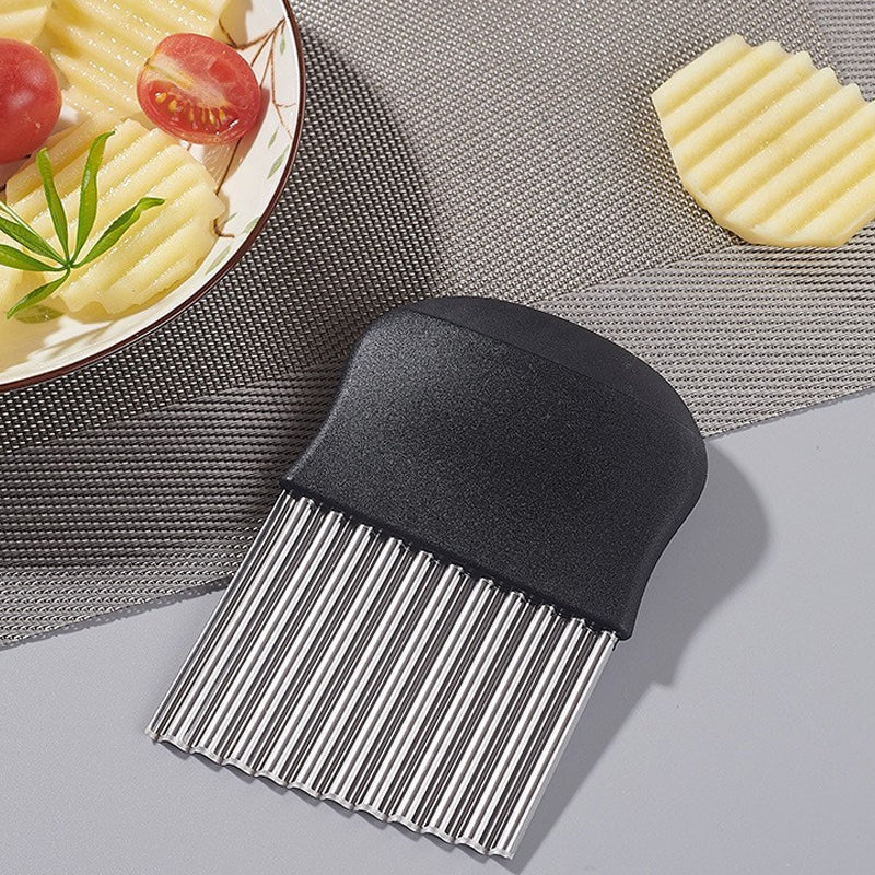 Couteau ondulé à poignée noire posé près d'une assiette de pommes de terre