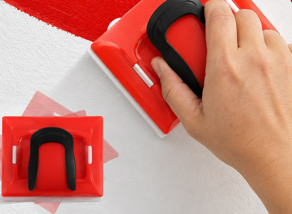 Main qui guide l'outil de bordure le long d'un trait de peinture rouge